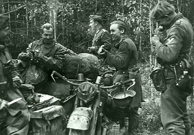 Прием пищи немецких мотоциклистов в лесу под Вязьмой. На фото — мотоцикл с коляской BMW R-12. октябрь 1941 Автор: Моссдорф (Mossdorf) 
