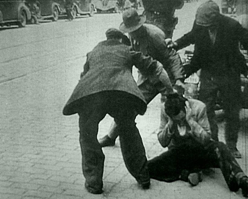 Избиение еврея во время погрома в оккупированном немецкими войсками Львове. Место съемки: Львов, Украина.  Время съемки: 1941. 