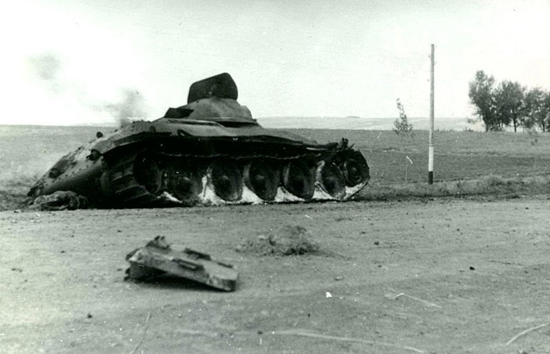 Подбитый на дороге советский танк Т-34 и погибший советский танкист