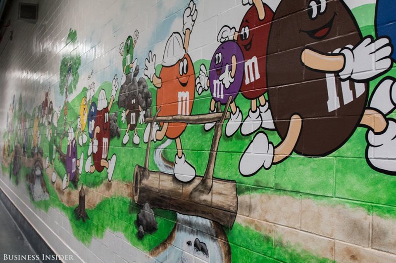 Тур по фабрике начинается с коридора, украшенного яркими рисунками персонажей M&M’s.