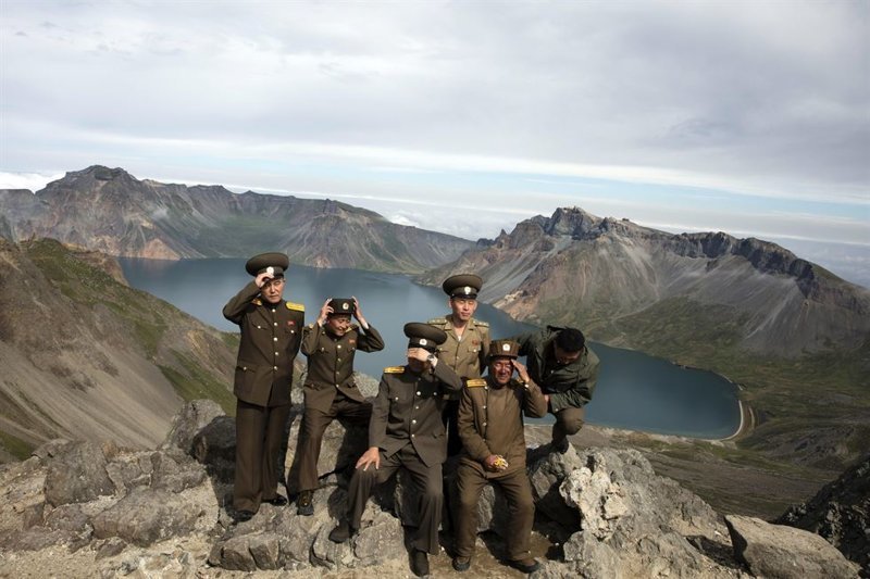 Северокорейские военные поправляют фуражки перед съемкой 