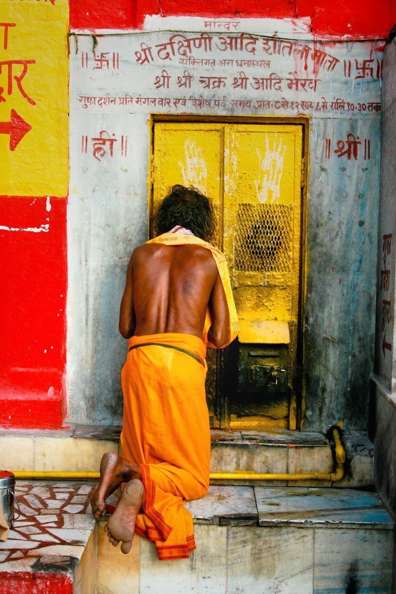 4. Мужчина молится у двери храма легендарного города Варанаси, Индия