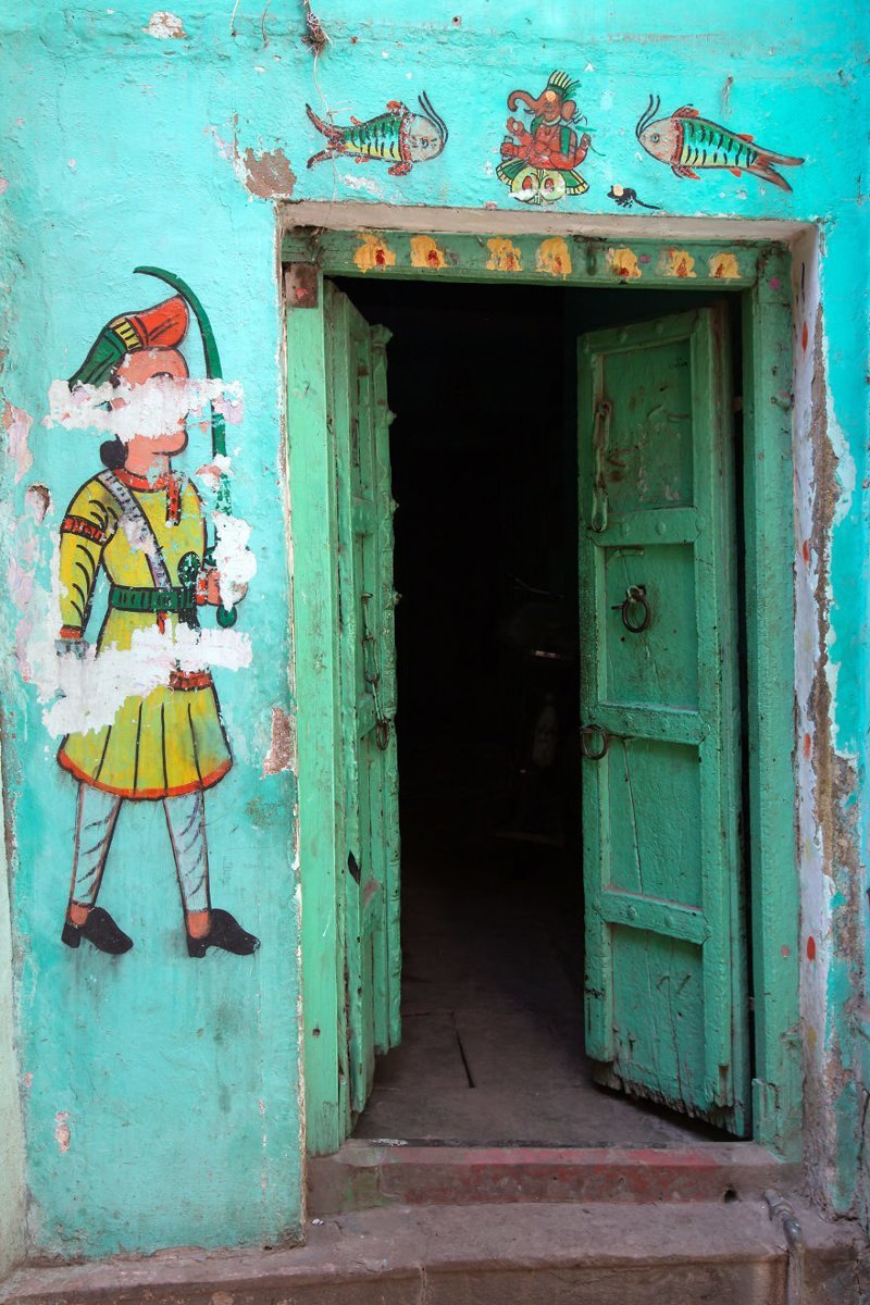 13. Рисунки на стенах рядом с дверью в старой части священного города Варанаси, Индия