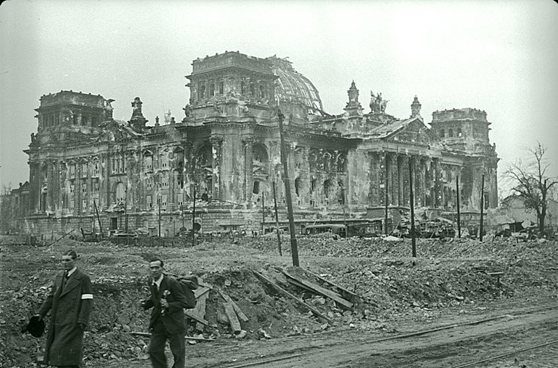 47. "Мирные" жители, призывного возраста, проходят возле здания Рейхстага в Берлине после боев.