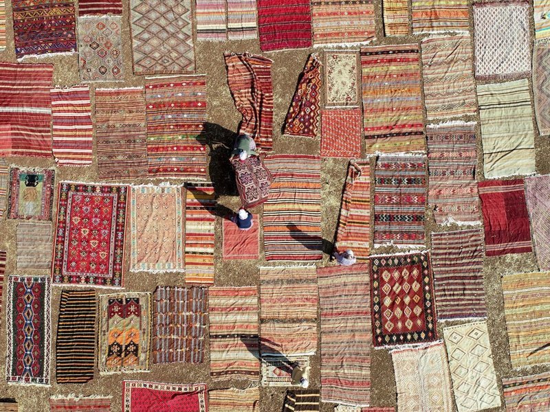 Около 30 000 ручных турецких ковров лежали на полях в Анталии, они выставлены на солнце, чтобы смягчить их цвета, 10 августа 2018 года
