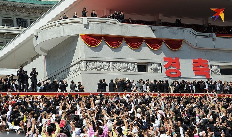 Лидер КНДР Ким Чен Ын приветствует народ с трибуны