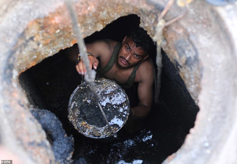 Джони (на фото) - один из многих, кто вручную чистит канализационные шахты в Газиабаде без какого бы то ни было защитного снаряжения