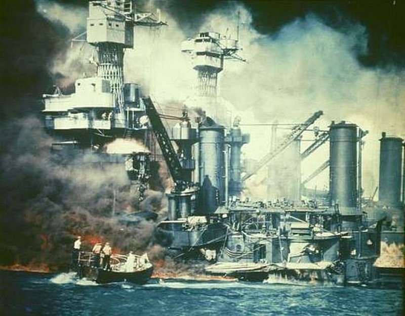 Небольшая лодка спасает члена экипажа USS West Virginia из воды после японской бомбардировки Перл-Харбора, Гавайи, 7 декабря 1941 года . 