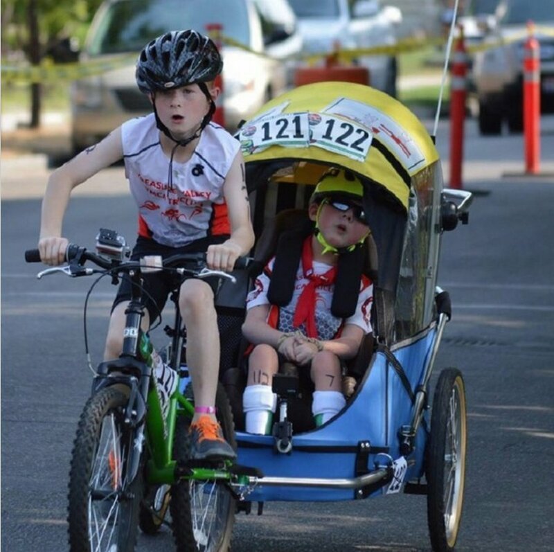 В соревнованиях по триатлону участвует 12-летний Ной и его брат Лукас в инвалидной коляске