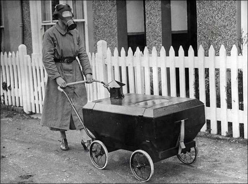 Женщина с ребенком в коляске, готовые к газовой атаке, Англия, 1938.