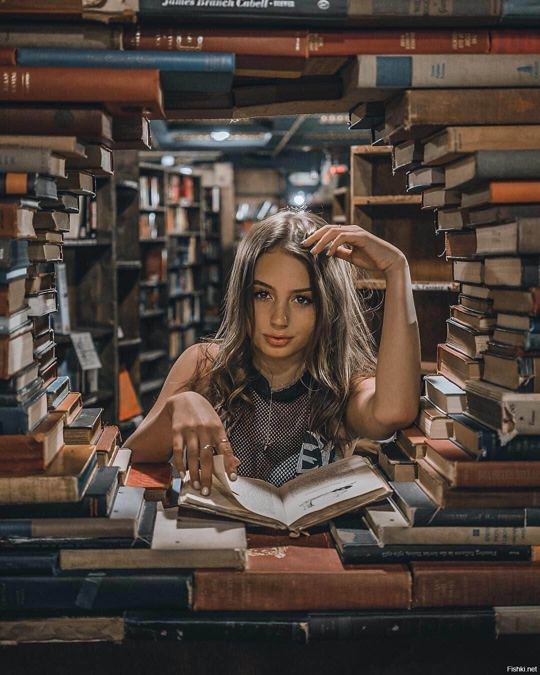 Она сидит в библиотеке. Умная девушка. Красивая умная девушка. Девушка в библиотеке. Фотосессия в библиотеке идеи.