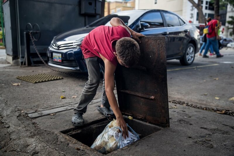 15-летний Эдисон прячет пакет со своей одеждой в канализационном люке в районе Лас-Мерседес