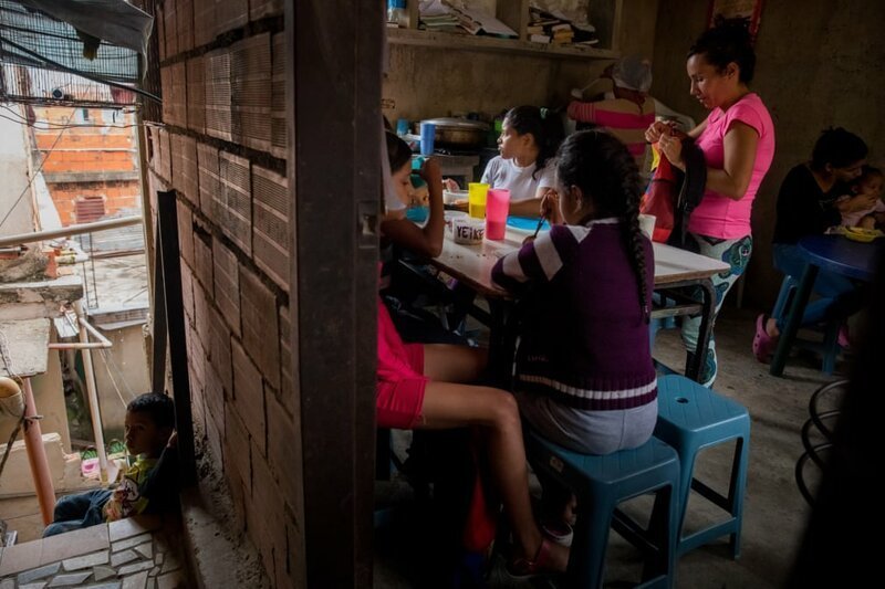 Дети обедают в благотворительной столовой, которая была создана группой матерей и общественных деятелей в рамках социальной инициативы под названием Caracas Mi Convive