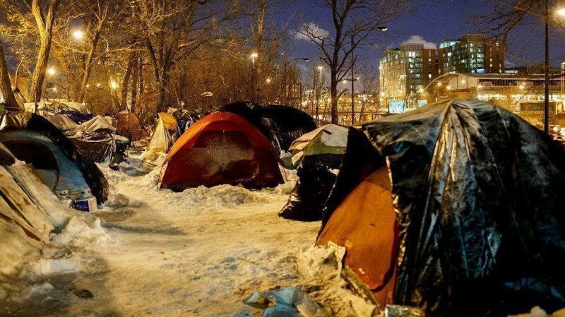 Бездомные спят в палатках среди деревьев у оживленного шоссе, снимок от 29 января