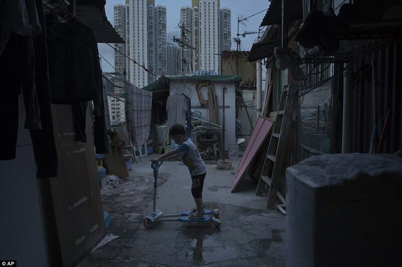 5-летний мальчик играет около крошечного дома, сделанного из бетона и гофрированного металла, где он живет вместе с родителями.