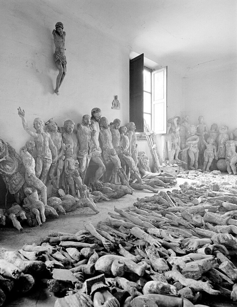Комната хранения со спасенными изображениями и скульптурами, ожидающими восстановления после наводнения во Флоренции, Италия, в 1966 году. Жутко...