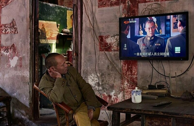 "Местные жители приходят в чайный дом покурить, пообщаться, рассказать об успехах и посмотреть военные фильмы по телевизору", - рассказал Саймон Урвин о фотографии, сделанной в китайской провинции Сычуань (категория "Портфолио")