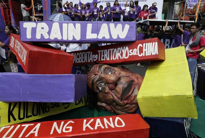 Голова президента Филиппин Родриго Дутерте под цветными бумажными блоками с призывами. Манила, Филиппины