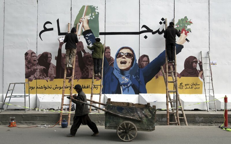 14. Независимые афганские художники рисуют граффити на стене Министерства по делам женщин, чтобы отметить Международный женский день в Кабуле