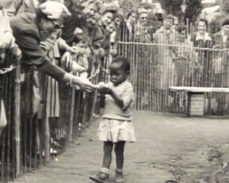 Негритянская девочка в вольере человеческого зоопарка. Брюссель. Бельгия. 1958 год. 