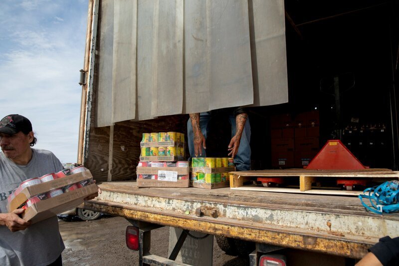 Поденщики и волонтеры выгружают продукты во время экстренной доставки, Оглала, Южная Дакота