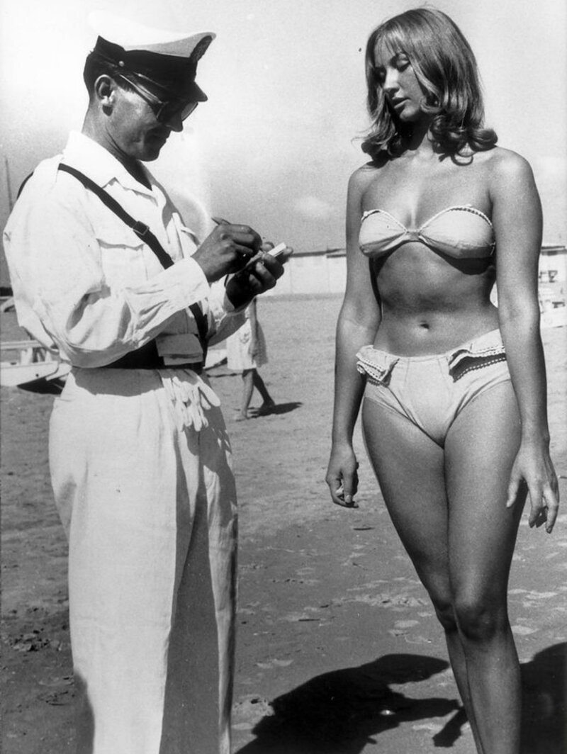 Полицейский выдает женщине билет на ношение бикини на пляже в Римини, Италия, в 1957 году . 
