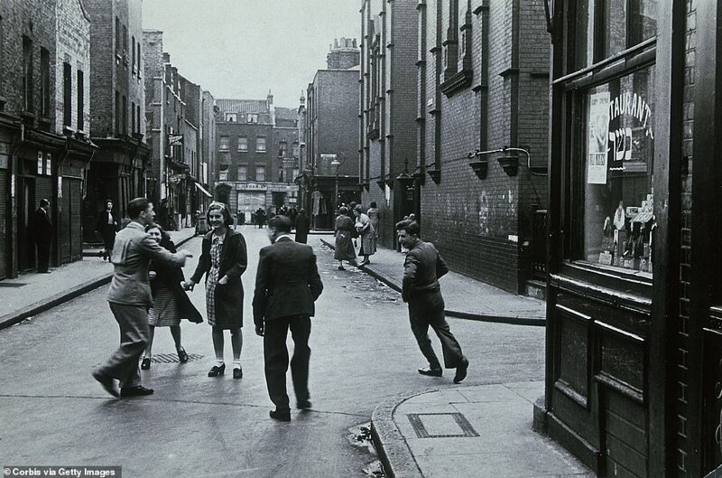 Люди играют на улице в одном из трущобных районов Уайтчепела, 1930-е годы