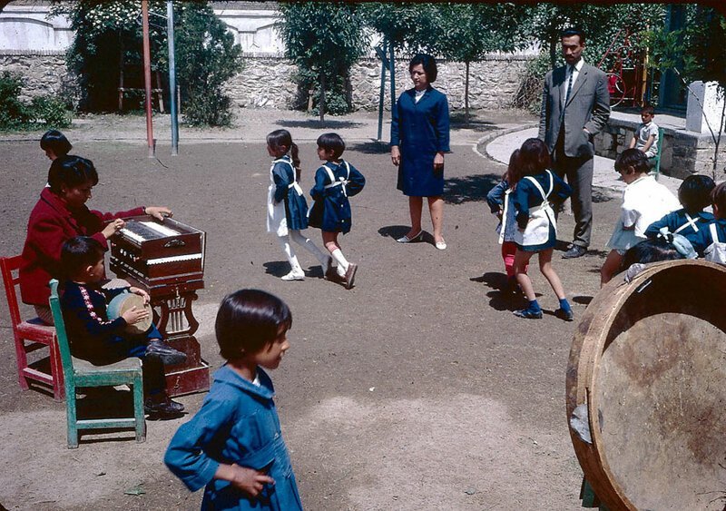 Маленькие ученицы танцуют в синей униформе на школьной площадке