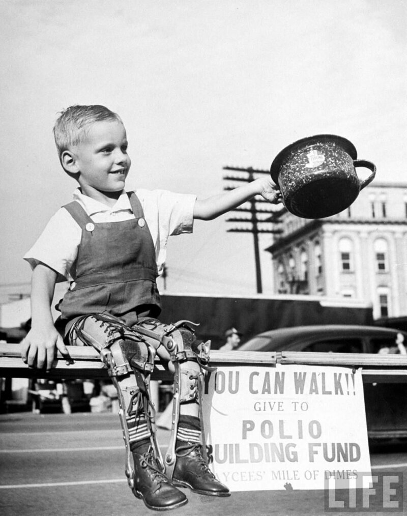 Дэвид Хэнсли, маленький ребенок, искалеченный полиомиелитом с обеими ногами в скобках, собирает средства в государственном агентстве по сбору средств для новой больницы для полиомиелита. High Point, NC 1948. 