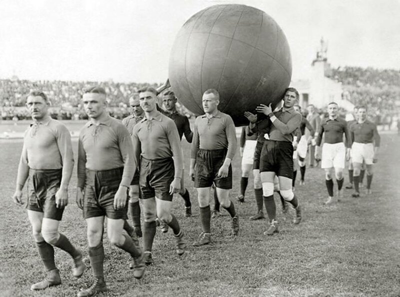 Команда несёт огромный мяч на стадион перед игрой в «пушбол». Этот вид спорта родом из США