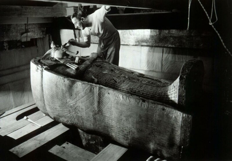 1. Археолог Говард Картер смахивает пыль с саркофага с мумией фараона Тутанхамона. (Harry Burton)