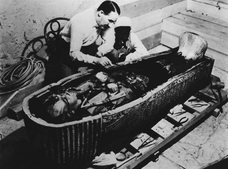 14. На этом недатированном снимке Говард Картер – археолог, открывший гробницу Тутанхамона – исследует его саркофаг.