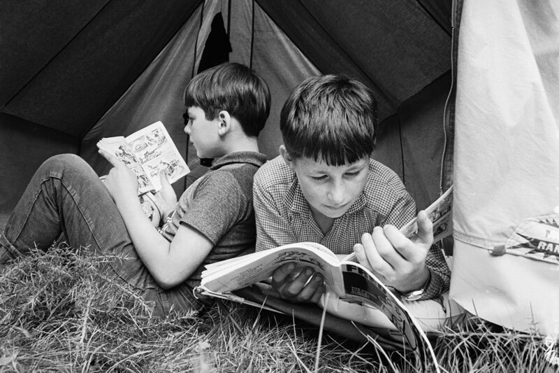 Мальчики читают комиксы в своей палатке в летнем лагере, организованном Национальной ассоциацией одаренных детей в 1967 г.