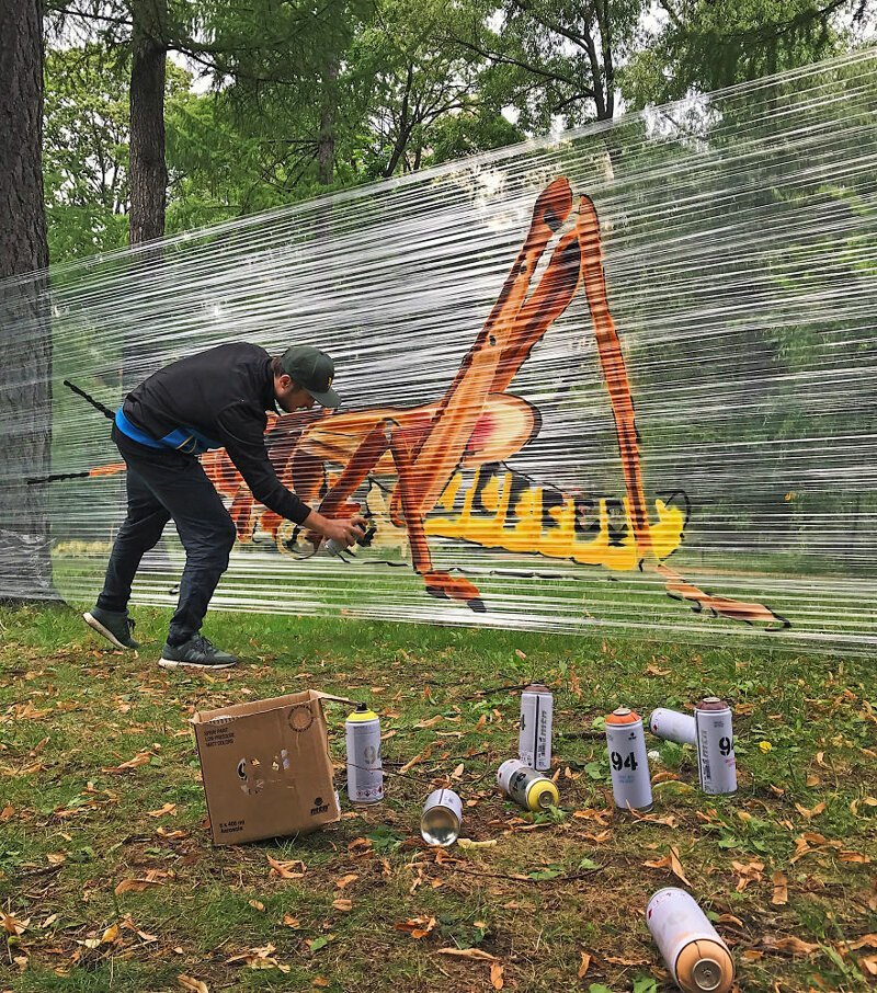 Московский художник рисует граффити на прозрачной пленке
