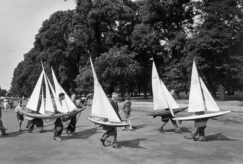 Солнечным воскресным днём группа людей с моделями лодок направляется к Круглому пруду в Гайд-парке, Лондон.