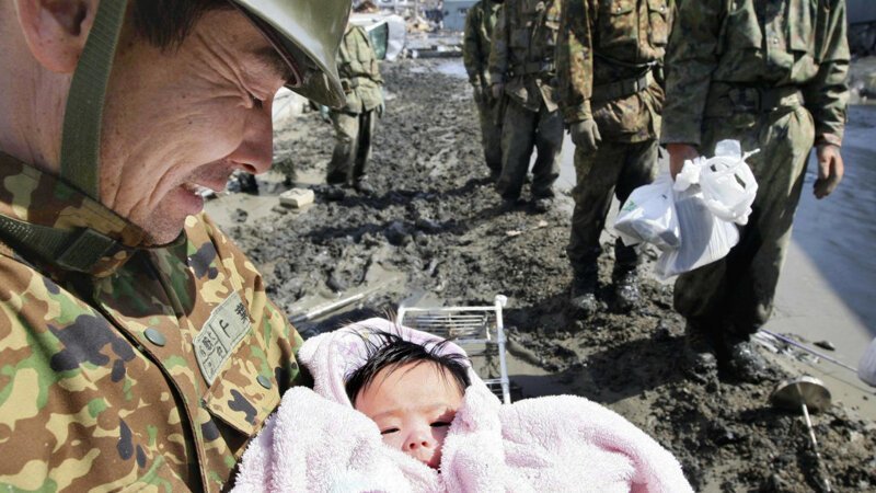 14. Солдат, нашедший живого ребенка после разрушительного цунами в Японии в 2011 году