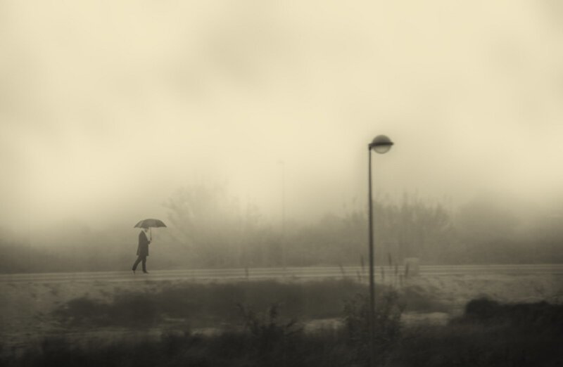 Мужчина и зонтик как символ одиночества в мире