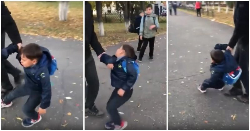 Первоклассник пытается вырваться из рук отца, потому что не хочет идти в школу