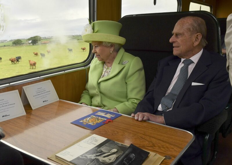 Елизавета II и принц Филипп едут на паровозе мимо города Колрейн, Северная Ирландия.