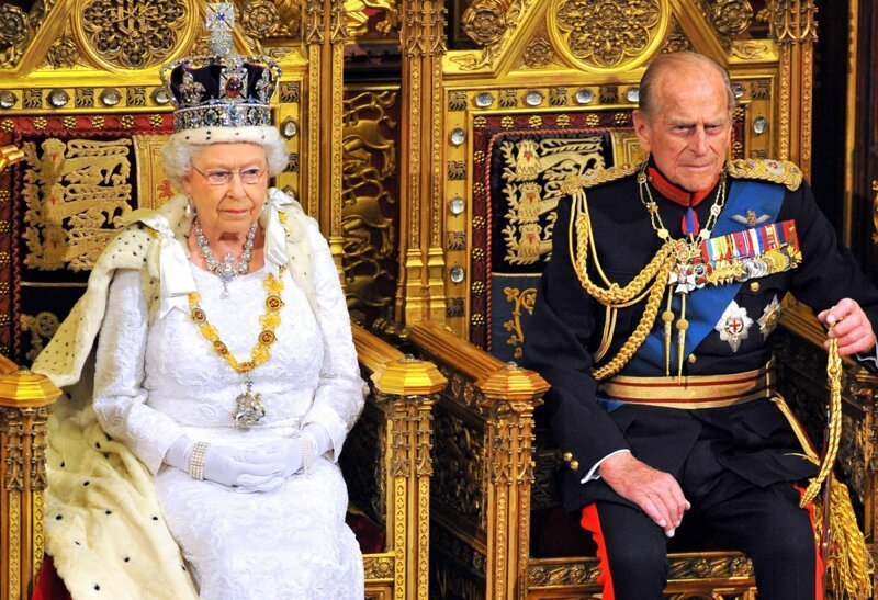 Филипп сидит с Ее Величеством, пока она произносит речь в Парламенте.