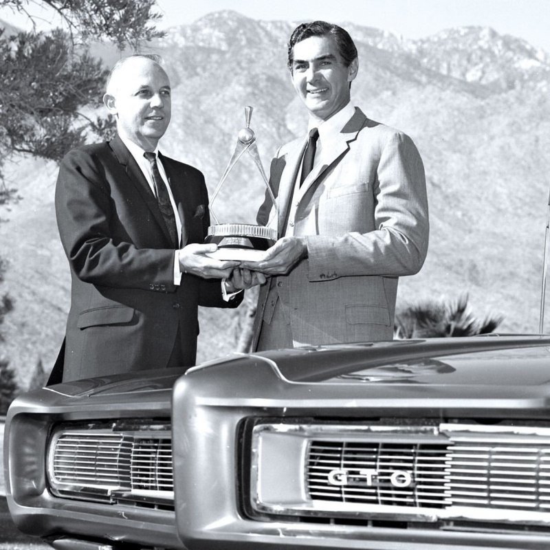 Джон Делореан (справа) получает награду за десять лет работы в General Motors — как главный инженер автомобиля Pontiac GTO