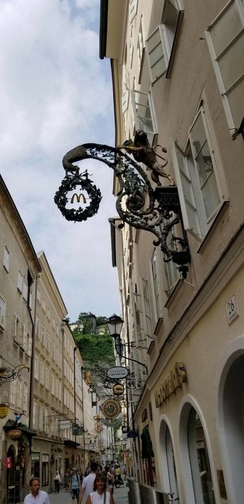 Вывеску "Макдональдса" в старинном стиле, чтобы соответствовать духу улицы, Зальцбург, Австрия