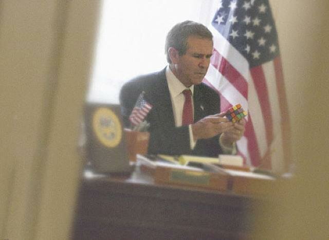 Президент Джордж Буш-младший пытается собрать кубик Рубика