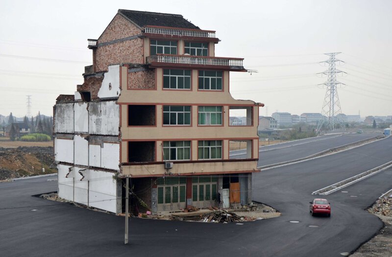 Через деревню Вэньлин в провинции Чжэцзян проложили дорогу, которая с двух сторон огибает жилое здание. Пожилая семейная пара отказалась подписать соглашение о сносе их дома