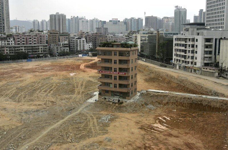 Одинокое шестиэтажное здание высится на стройплощадке будущего финансового центра в деловом районе Шэньчжэня