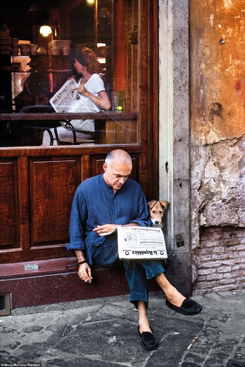 Мужчина за чтением газеты и его питомец на ступеньках закусочной, Рим, Италия, 1994 год
