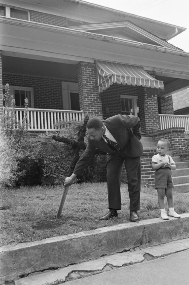 7. Мартин Лютер Кинг убирает обгоревший крест со своего газона на глазах у сына