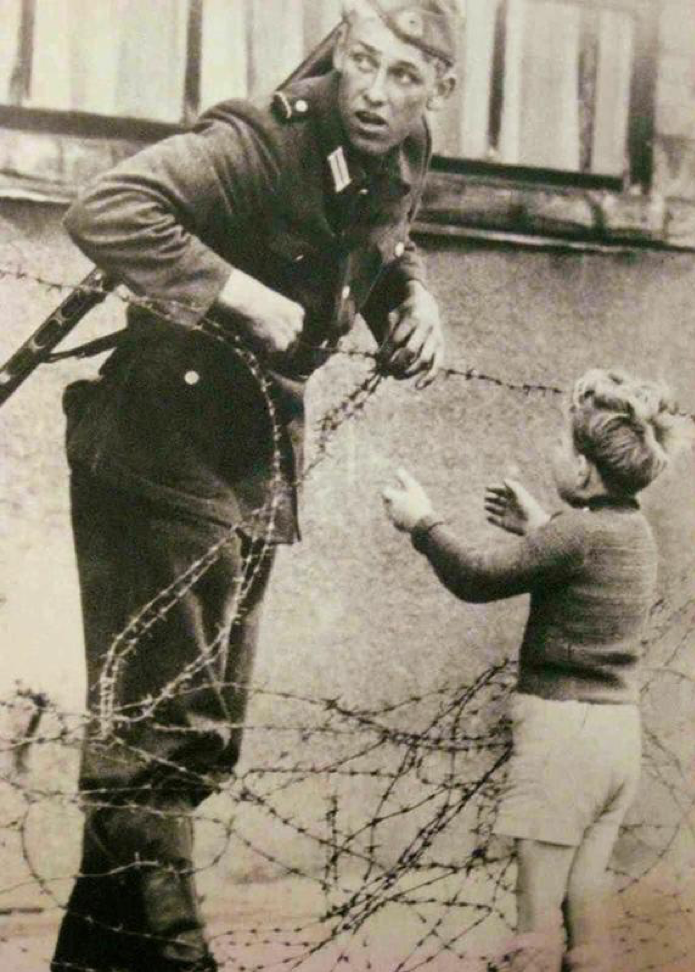 4. Солдат помогает мальчику перебраться через Берлинскую стену