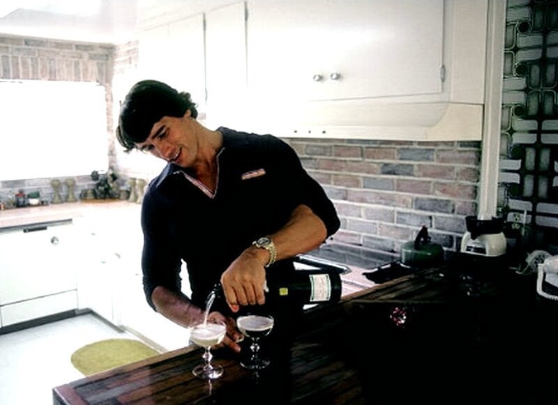 Австрийский культурист Арнольд Шварценеггер наливает шампанское дома в августе 1977 года в Лос-Анджелес, Калифорния. 