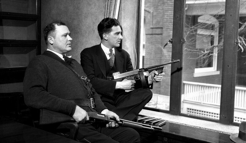 Полицейские охраняют здание суда во время процесса над знаменитым грабителем банков Джоном Диллинджером, 30 января 1934 года. 